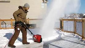Woman using an electric snowblower